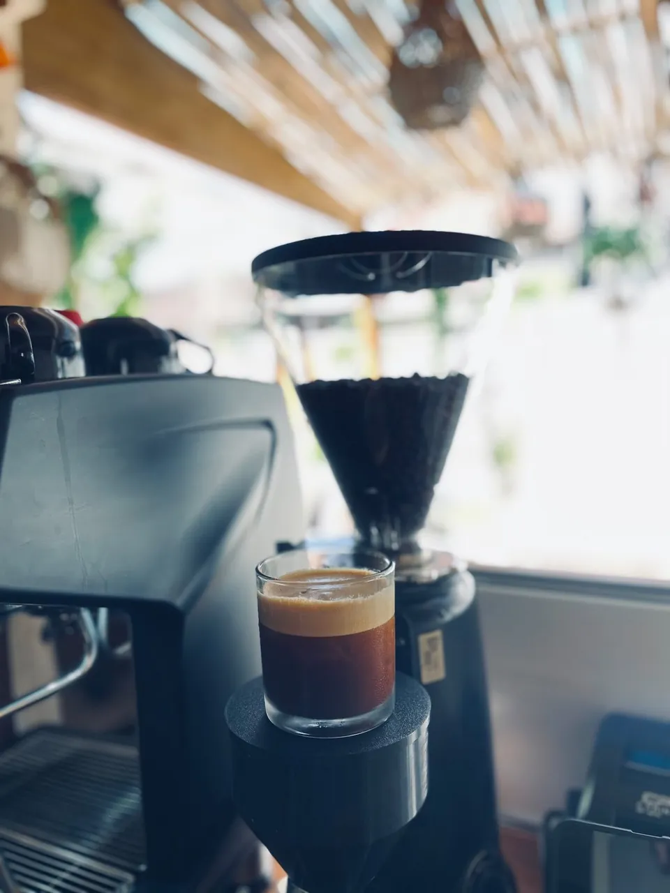 A fresh espresso shot under the grinder on the ME'RONA bar